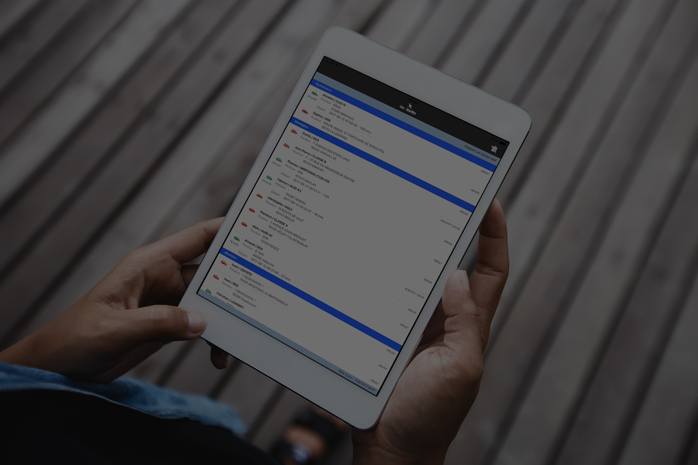 Une personne tenant une tableau qui a l'application GeoCoyote afin de gérer sa flotte de véhicules